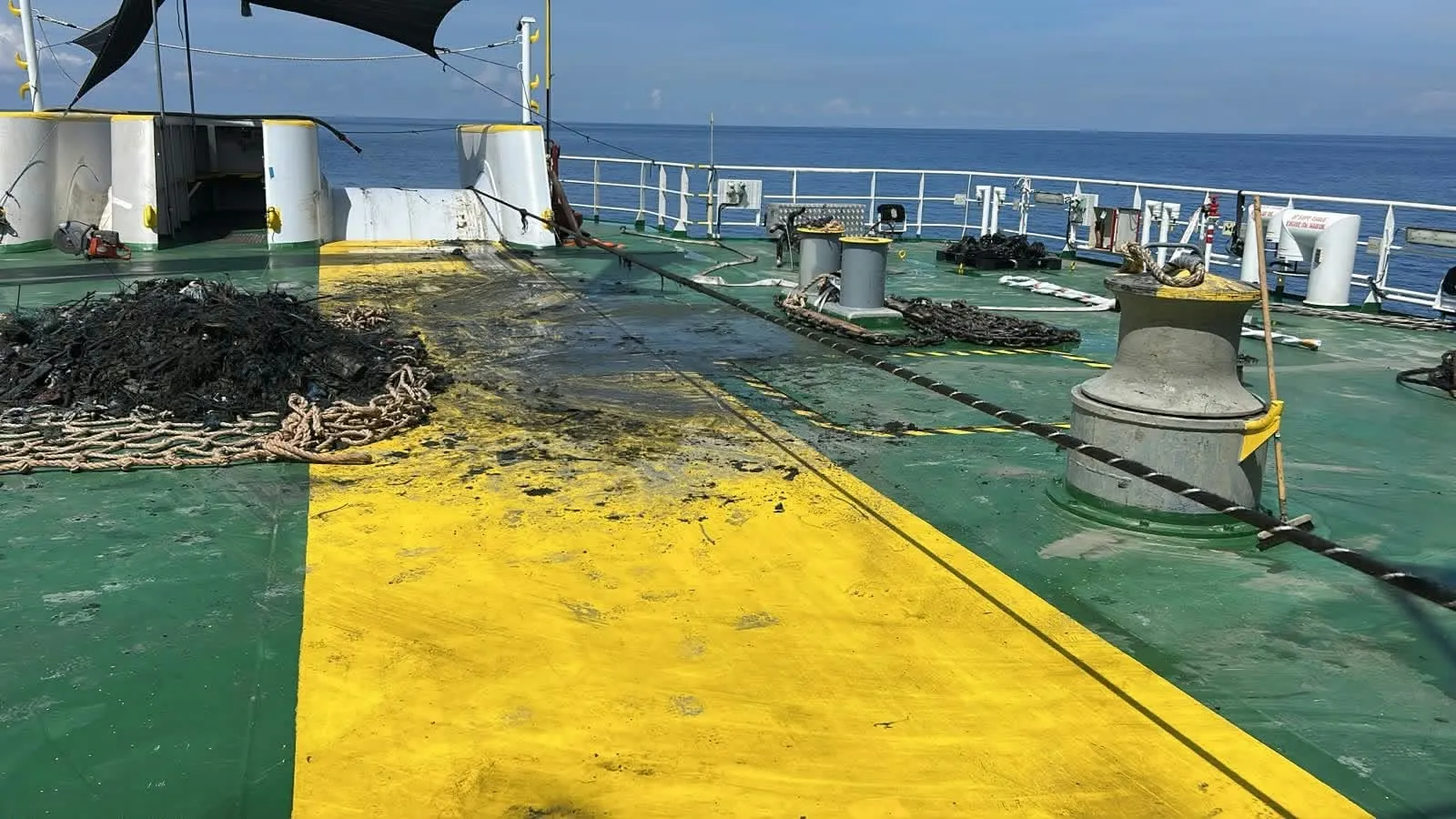 Submarine cable recovery: deck partly cleared, debris gathered on a cargo net